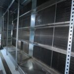 Figure 2: Multiple rows of bipolar ionization bars, supported on the upstream face of a cooling coil, in a large capacity air handling unit. Courtesy: CDM Smith