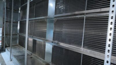 Figure 2: Multiple rows of bipolar ionization bars, supported on the upstream face of a cooling coil, in a large capacity air handling unit. Courtesy: CDM Smith