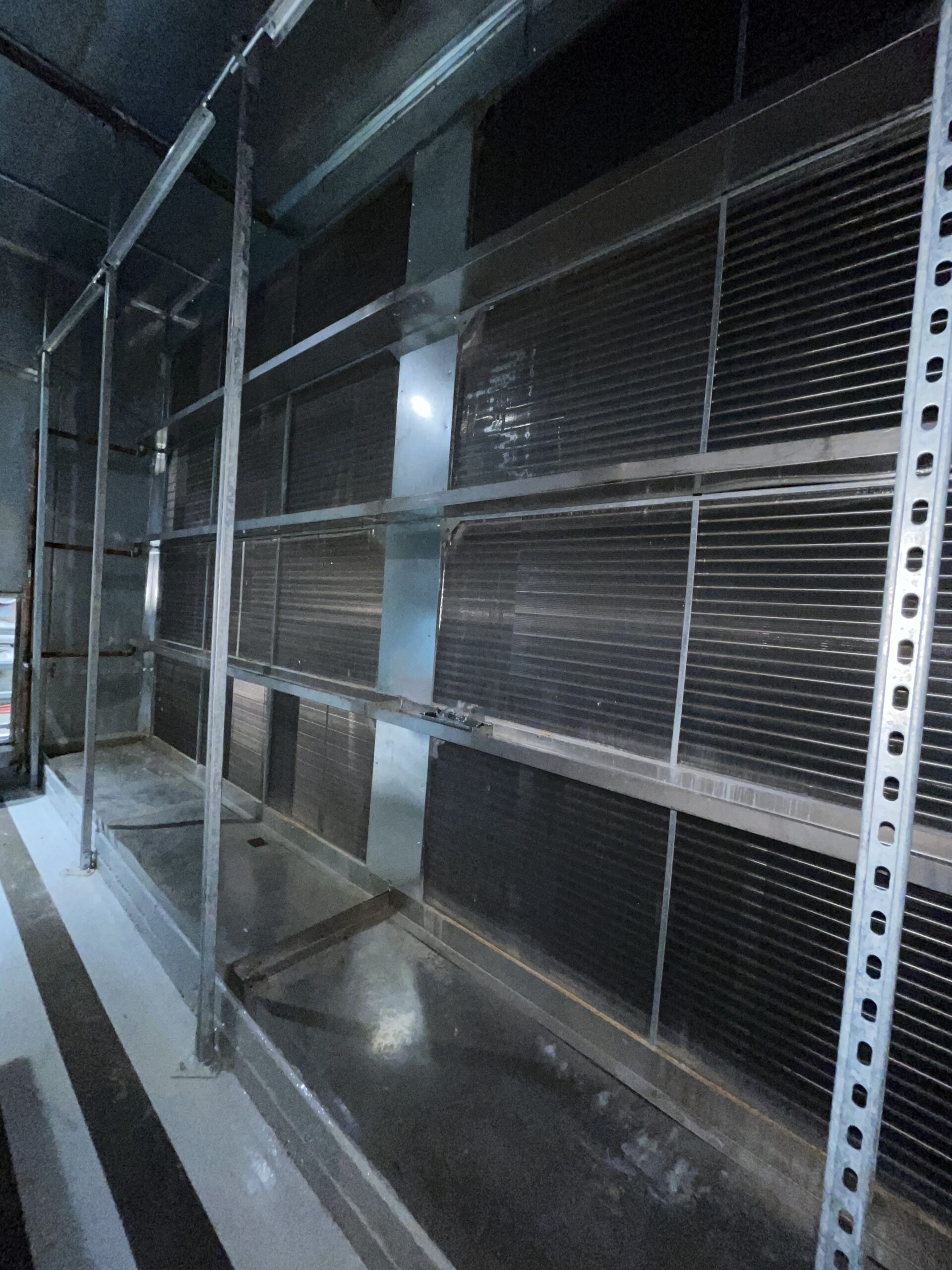 Figure 2: Multiple rows of bipolar ionization bars, supported on the upstream face of a cooling coil, in a large capacity air handling unit. Courtesy: CDM Smith