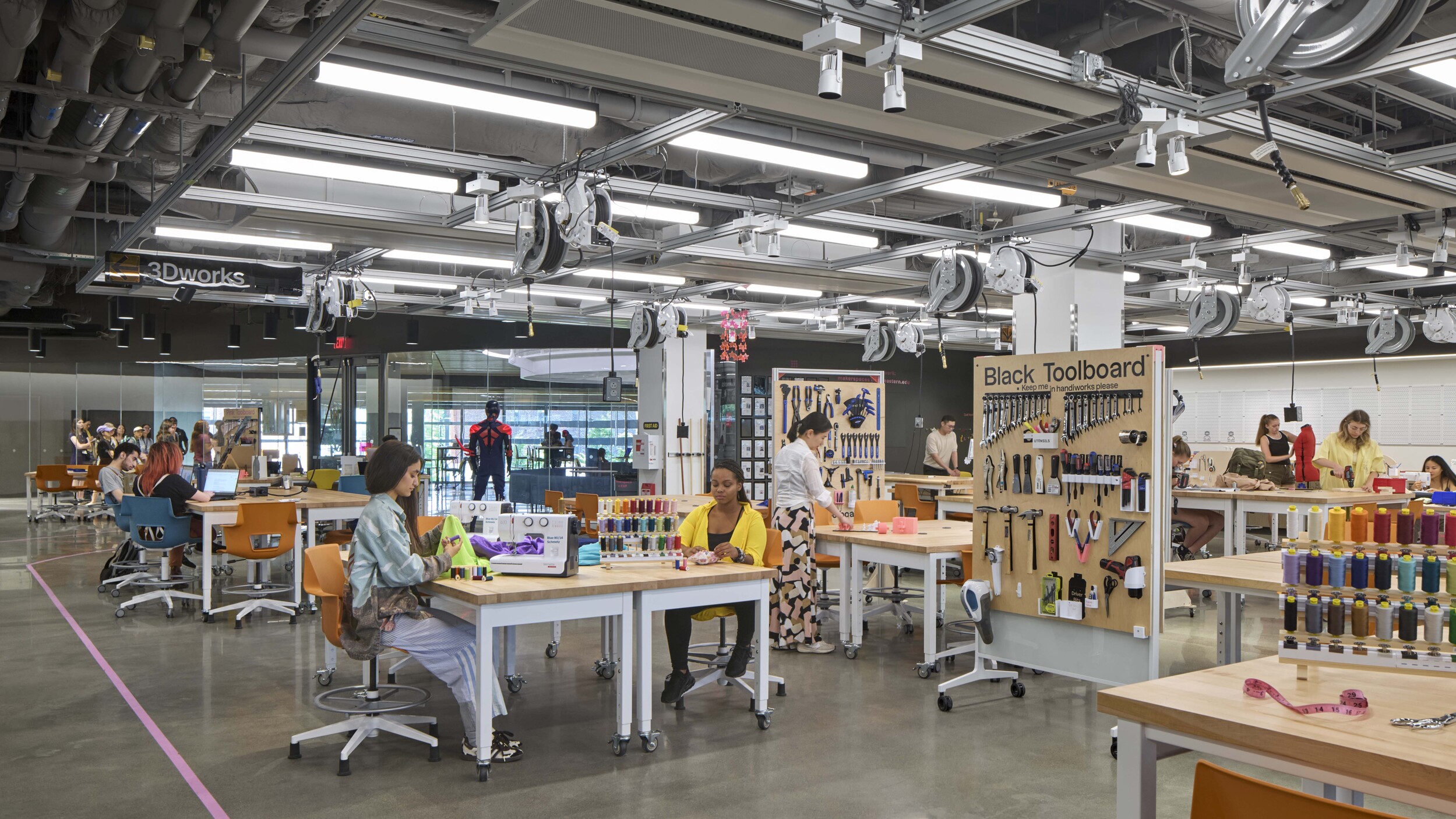 In the primary makerspace, general lighting uses networked wireless lighting control with occupancy sensors, daylight sensors and local keypads with dimming capability. Supplemental track-mounted task lights allow for complete adjustability and use Bluetooth control for individual luminaire control. Courtesy: Robert Benson